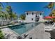 An inviting backyard pool and patio area is adjacent to a pristine white home with a red tile roof at 803 Gladiolus St, Anna Maria, FL 34216