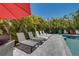 Seating and lounge chairs lining a beautiful, sunny pool area with privacy landscaping at 803 Gladiolus St, Anna Maria, FL 34216