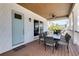 Inviting outdoor dining area on porch with table, seating for eight, and a welcome mat at the door at 803 Gladiolus St, Anna Maria, FL 34216