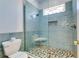Walk-in shower featuring ocean blue tiling, pebbled floor, and glass surround at 803 Gladiolus St, Anna Maria, FL 34216