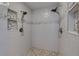 Modern walk-in shower with dual shower heads, built-in shelves, and decorative tiling at 803 Gladiolus St, Anna Maria, FL 34216