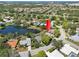 An aerial view highlighting the home's position in a lakeside community surrounded by mature trees and manicured landscapes at 8146 Shadow Pine Way, Sarasota, FL 34238
