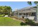 A screened-in pool surrounded by tropical landscaping with palm trees and blooming flowers, creating a private retreat at 8146 Shadow Pine Way, Sarasota, FL 34238