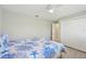 Cozy bedroom featuring a ceiling fan, closet, and doorway leading to a bathroom at 8146 Shadow Pine Way, Sarasota, FL 34238