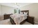 Inviting bedroom with a dark wooden dresser, ceiling fan, and neutral-toned bedding at 8146 Shadow Pine Way, Sarasota, FL 34238