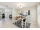 Dining area with a wooden table and views into the kitchen, featuring tile floors and a modern light fixture at 8146 Shadow Pine Way, Sarasota, FL 34238