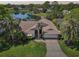 Beautiful single-story home with lush landscaping, mature palms, and a serene lake view at 8146 Shadow Pine Way, Sarasota, FL 34238