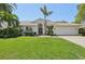Charming single-story home featuring a well-manicured lawn, mature palms, and a two car garage at 8146 Shadow Pine Way, Sarasota, FL 34238