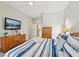 Main bedroom features a ceiling fan, wood dresser, and a television for relaxing evenings at 8146 Shadow Pine Way, Sarasota, FL 34238