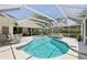 Open-air pool with a covered sitting area and hot tub framed by palm trees and privacy hedges at 8146 Shadow Pine Way, Sarasota, FL 34238