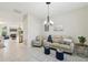 Cozy seating area with a sofa, armchair, and view into the open plan kitchen and dining area at 8146 Shadow Pine Way, Sarasota, FL 34238