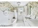 Charming bathroom with a clawfoot tub, double sinks, floral wallpaper, and bright white tile at 829 Bayshore Blvd, Tampa, FL 33606
