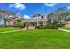 Well-maintained two-story home with lush green lawn, mature trees, and an inviting front porch at 829 Bayshore Blvd, Tampa, FL 33606