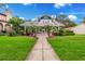 Charming two-story home with a manicured lawn, walkway, and inviting front porch lined with tropical palm trees at 829 Bayshore Blvd, Tampa, FL 33606
