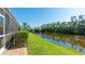 Landscaped backyard with lush green grass and canal at 9226 13Th Avenue Nw Cir, Bradenton, FL 34209