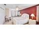 Bedroom with a white bed, built in bench and large window, and a red accent wall at 9226 13Th Avenue Nw Cir, Bradenton, FL 34209