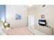 Bright bedroom featuring a queen-sized bed, dresser with a TV, and a bedside table with a lamp at 9226 13Th Avenue Nw Cir, Bradenton, FL 34209