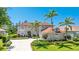 Two-story home featuring palm trees, a spacious driveway, manicured lawn, and an attached three-car garage at 9226 13Th Avenue Nw Cir, Bradenton, FL 34209