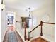 Light hallway with hardwood floors, a wood and white staircase, and decorative lighting at 9226 13Th Avenue Nw Cir, Bradenton, FL 34209
