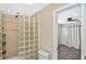 Updated bathroom featuring a glass block shower and view to the adjacent bedroom at 1011 Bacon Ave, Sarasota, FL 34232