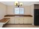 Dining area features built-in cabinetry with wood countertop, a black refrigerator and a window at 1011 Bacon Ave, Sarasota, FL 34232