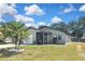 Charming single-story home featuring a screened porch, attached garage, and well-maintained lawn under a bright blue sky at 1011 Bacon Ave, Sarasota, FL 34232