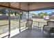 Screened patio features two wicker chairs and views of the backyard at 1011 Bacon Ave, Sarasota, FL 34232