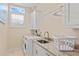 Well-lit laundry room featuring a front-load washer and dryer and sink at 1021 Crescent St # 1, Sarasota, FL 34242