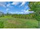 Scenic backyard featuring a lush green lawn and surrounding landscaping within a quiet neighborhood setting at 10616 High Noon Trl, Parrish, FL 34219