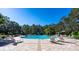 Resort-style community pool with ample lounge seating, perfect for relaxation and recreation under the sun surrounded by mature trees at 10616 High Noon Trl, Parrish, FL 34219