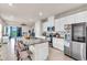 Modern kitchen with stainless appliances, an island with seating, and a view to the living space at 10616 High Noon Trl, Parrish, FL 34219