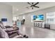 Comfortable living room featuring tile floors and a modern ceiling fan at 10616 High Noon Trl, Parrish, FL 34219