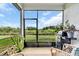 Enclosed patio with wicker furniture and a BBQ grill overlooking a serene outdoor view at 10616 High Noon Trl, Parrish, FL 34219
