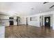 Open-concept kitchen and living area with stainless steel appliances, white cabinets, and hardwood floors at 10712 Forest Run Dr, Bradenton, FL 34211
