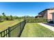 Expansive backyard with lush greenery, a black fence, and tranquil pond views at 10806 52Nd E Ct, Parrish, FL 34219