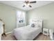 Bright bedroom showcases a ceiling fan, white headboard, large window, and hardwood flooring at 10806 52Nd E Ct, Parrish, FL 34219