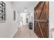 Bright hallway with wood floors and a decorative sliding barn door at 10806 52Nd E Ct, Parrish, FL 34219