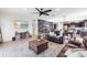 Open concept living room with ceiling fan, rustic accent wall, an entertainment center, and view to kitchen at 10806 52Nd E Ct, Parrish, FL 34219