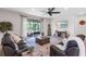 Comfortable living room showcasing leather couches, a ceiling fan, an entertainment center, and a sliding door to patio at 10806 52Nd E Ct, Parrish, FL 34219