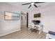 Bright home office features modern desk, ceiling fan, large screen TV, and rustic décor at 10806 52Nd E Ct, Parrish, FL 34219
