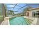 View of the screened pool and patio area with built-in spa and outdoor seating, overlooking the lake at 11215 Rivers Bluff Cir, Lakewood Ranch, FL 34202