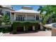 Two-story home showcasing a garage with plant-covered pillars at 1435 Westway Dr, Sarasota, FL 34236