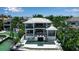 Luxurious waterfront home featuring a sleek pool, covered outdoor seating, and lush tropical landscaping at 1435 Westway Dr, Sarasota, FL 34236