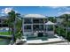 Luxurious waterfront home showcasing a sleek pool, covered outdoor seating, and tropical landscaping at 1435 Westway Dr, Sarasota, FL 34236