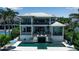 Luxurious waterfront home featuring a sleek pool, covered outdoor seating, and lush landscaping at 1435 Westway Dr, Sarasota, FL 34236