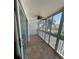 Enclosed balcony with a ceiling fan, tiled floors, and views of palm trees at 150 Harborside Ave # 221, Punta Gorda, FL 33950