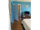 A blue bedroom featuring a window, a wood floor and a furniture piece at 150 Harborside Ave # 221, Punta Gorda, FL 33950