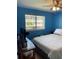 Bright blue bedroom featuring a window with an exterior view of other apartments at 150 Harborside Ave # 221, Punta Gorda, FL 33950