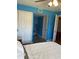 This blue bedroom features an open closet and access to the en-suite bathroom at 150 Harborside Ave # 221, Punta Gorda, FL 33950