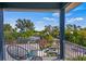 Relaxing balcony with seating and views of the lush landscaping, nearby neighborhood, and clear blue skies at 159 Crescent Dr, Anna Maria, FL 34216